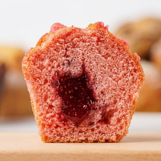 Close up of a sliced strawberry muffin with real strawberry filling