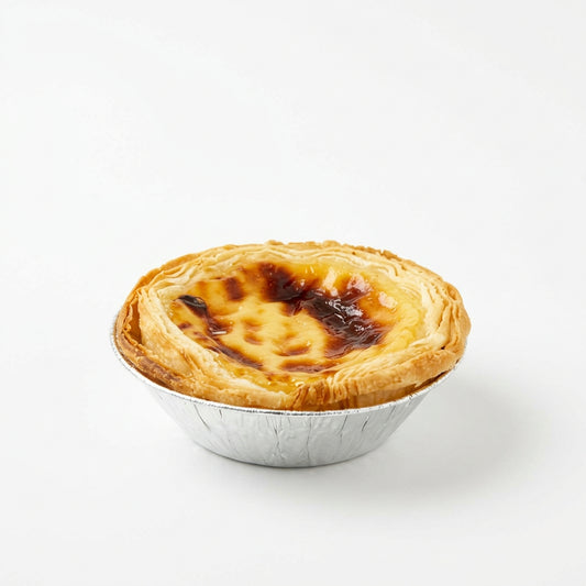Portuguese egg tart with custard filling in a foil case on a white background