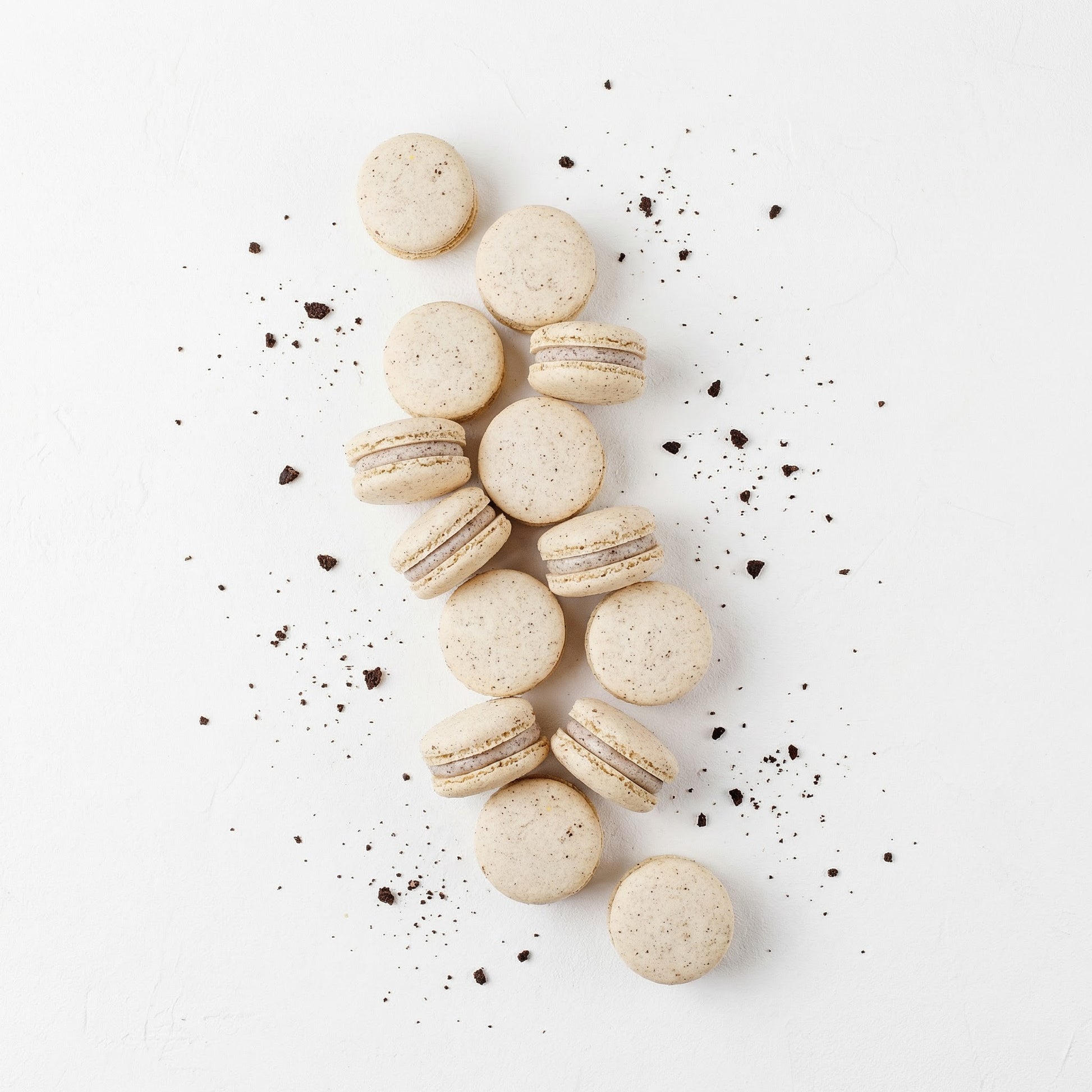 Cookies & Cream macarons with cookies shavings on a light background